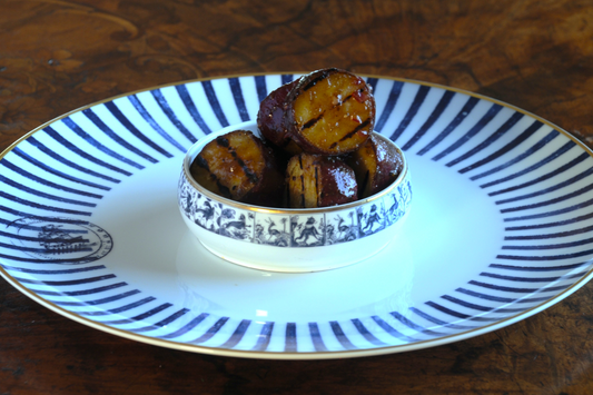Grilled white sweet potato rounds with tamarind glaze in a blue-and-white bowl, chef-prepared side dish delivered across the Algarve